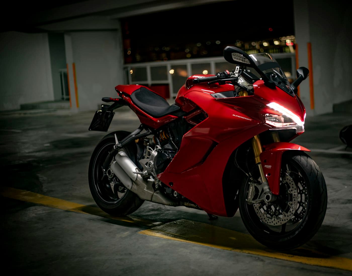 Motor sport merah dengan bodi mengilap di dalam garasi